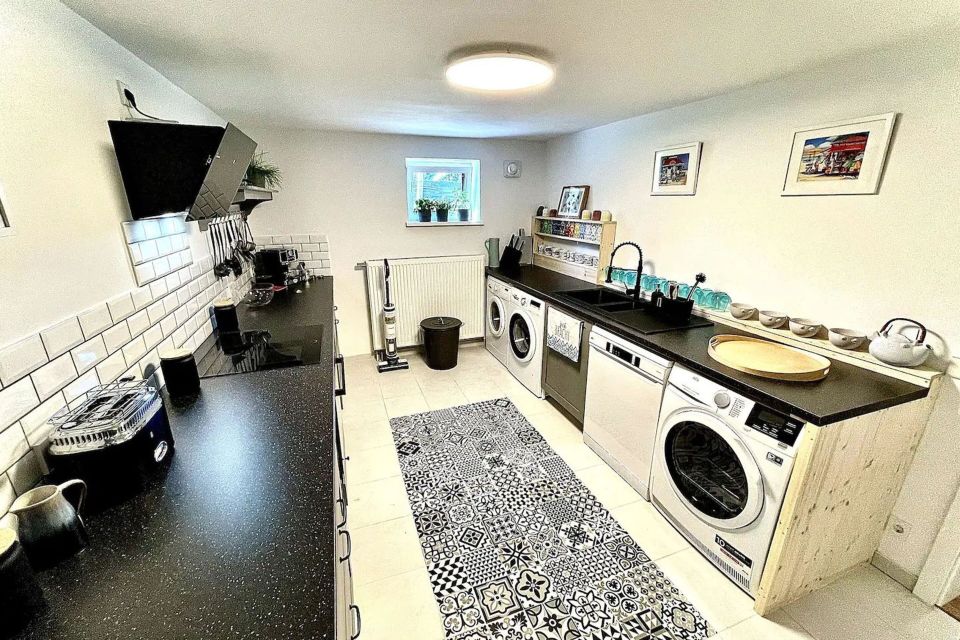 Küche mit 2 Waschmaschinen, Trockner, Spülmaschine, Wasserkocher, Filter-Kaffeemaschine, Espressomaschine, Toaster, Mikrowelle, Ofen, Foto: Hüller