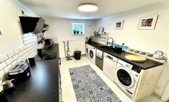 Küche mit 2 Waschmaschinen, Trockner, Spülmaschine, Wasserkocher, Filter-Kaffeemaschine, Espressomaschine, Toaster, Mikrowelle, Ofen, Foto: Hüller